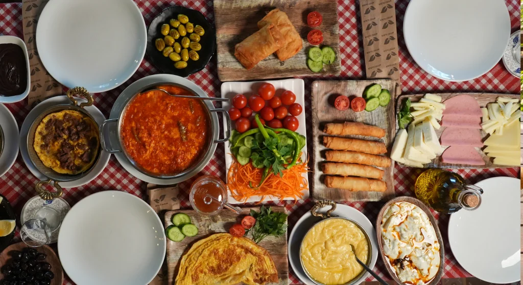 Edirne kahvaltılarının vazgeçilmezi sıcak pişi, lokma ve simit tabağı; yanında taze domates, salatalık söğüş ve kahvaltılık soslar.