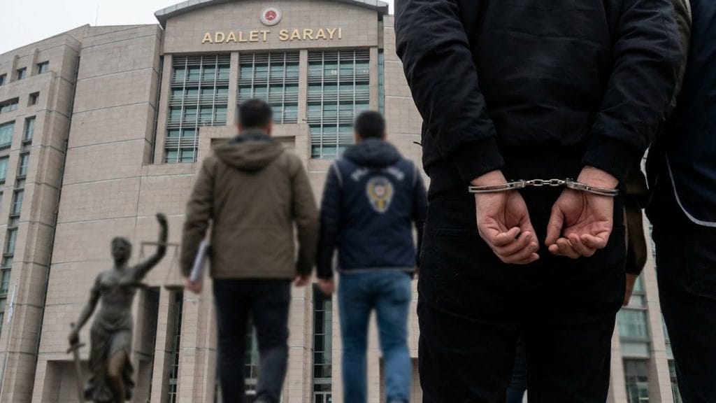 Bıçaklı saldırı şüphesilinin polis eşliğinde adliyeye sevk edilmesini ve tutuklanmasını simgeleyen görsel.
