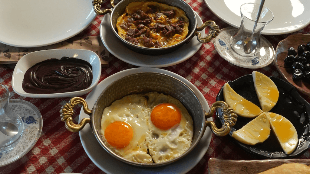 Edirne’de doğa ile iç içe kahvaltı mekanlarında, ahşap masalarda sunulan zengin serpme kahvaltılar; Trakya peynirleri, yöresel reçeller ve bakır çaydanlıkta demlenen çay eşliğinde keyifli bir kahvaltı deneyimi.