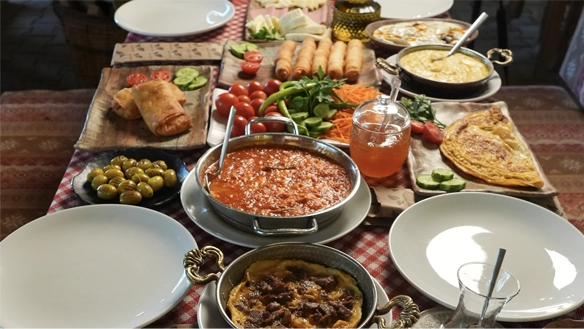 Edirne'de doğa ile iç içe, ahşap masada sunulan zengin serpme kahvaltı çeşitleri, Trakya peynirleri, bakır çaydanlık ve yöresel reçeller.