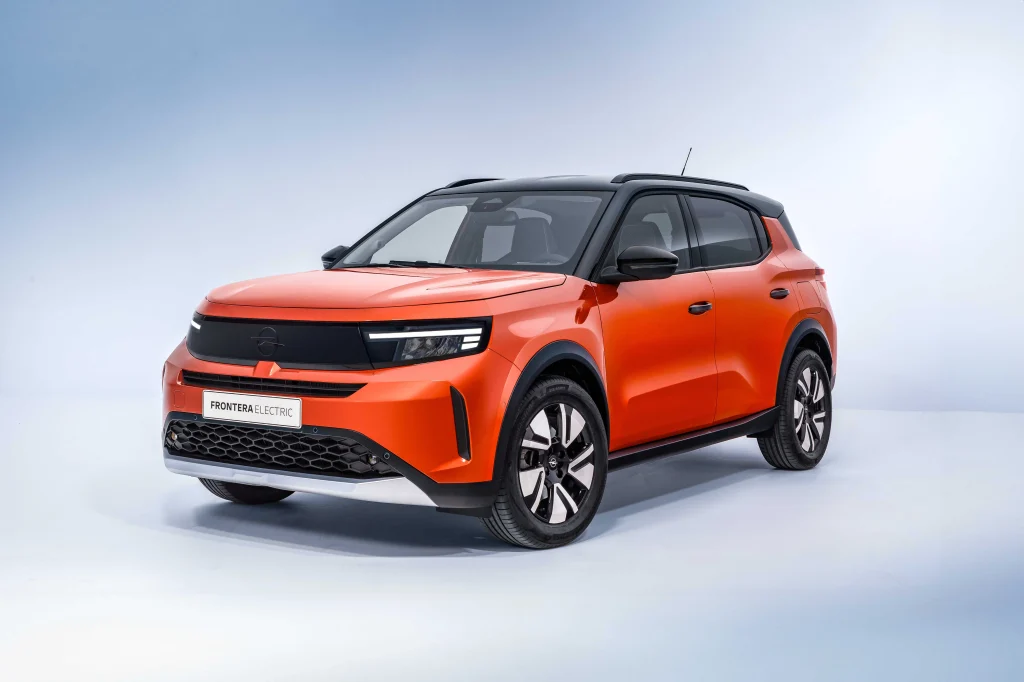 Turuncu renkli yeni Opel Frontera Electric SUV modelinin stüdyo ortamındaki önden görünümü.