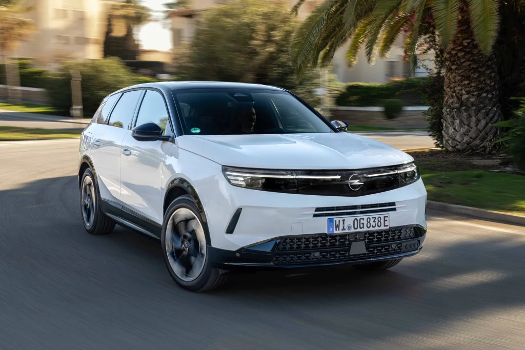 Hareket halindeki beyaz renkli yeni Opel Grandland Hybrid SUV modelinin önden görünümü.