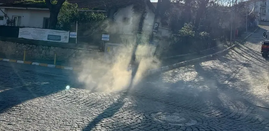 Bozcaada sokaklarındaki yağmur suyu kanallarından yükselen ilaçlama dumanı.