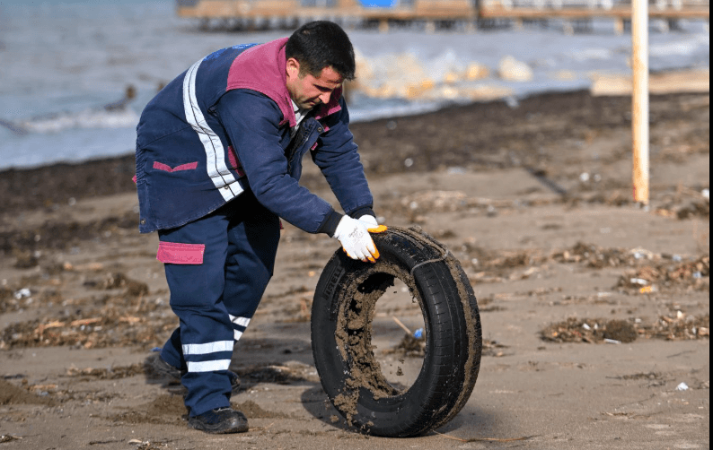 Çanakkale kordonunda biriken denizsel rüsubatın belediye personeli tarafından titizlikle süpürülmesi ve taşınması.