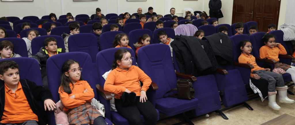 Belediye personelinin ilkokul öğrencilerine belediyenin çalışma prensiplerini anlattığı bilgilendirme toplantısı.