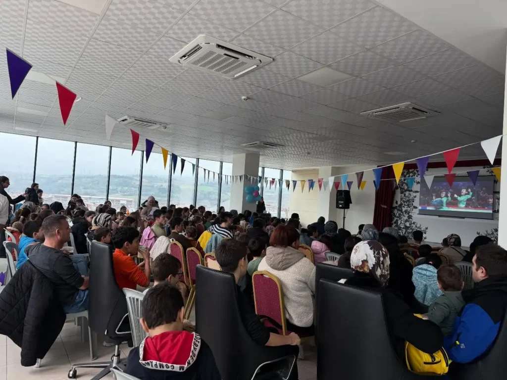 Lapseki'de düzenlenen film gösteriminde beyaz perdeyi ilgiyle ve neşeyle izleyen mutlu öğrenciler.