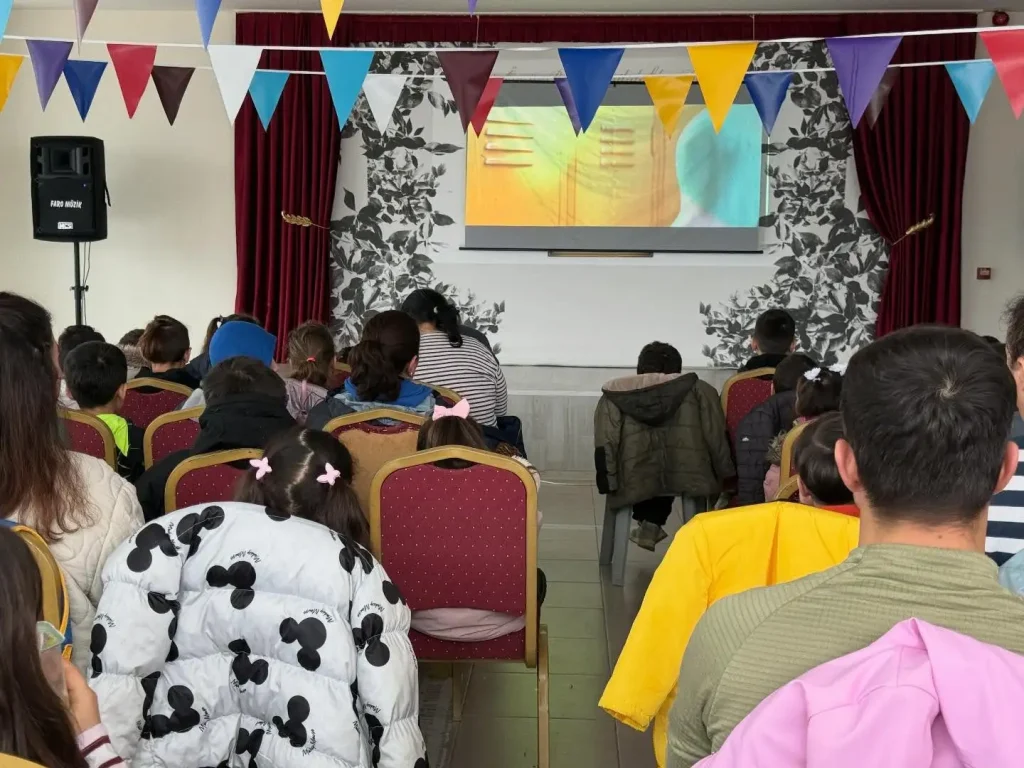 Çocuklarıyla birlikte sinema keyfi yapan aileler ve Lapseki Belediyesi sosyal belediyecilik etkinliği.