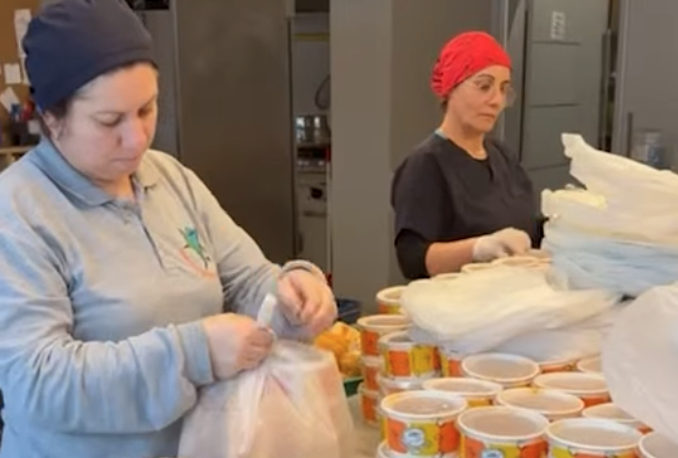 Lüleburgaz Belediyesi ekiplerinin, Sevgi Mutfağı'nda pişen yemekleri 'alan el veren eli görmeden' kapıya teslim etmek üzere araca yüklemesi.