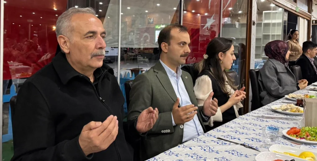 Eceabat Kaymakamı Kerem Yenigün ve Belediye Başkanı Saim Zileli, Şehit Onur Kıran anısına düzenlenen iftarda dua ederken.