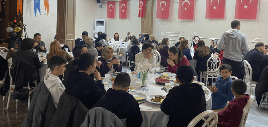 İftar sofrasında yemek yiyen çocuklar ve Türk bayrakları.