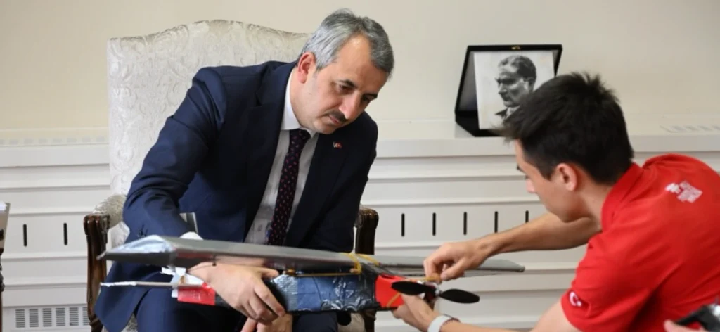 Vali Yunus Sezer, öğrencilerin tasarladığı insansız hava aracı (İHA) modelinin teknik detaylarını inceliyor.