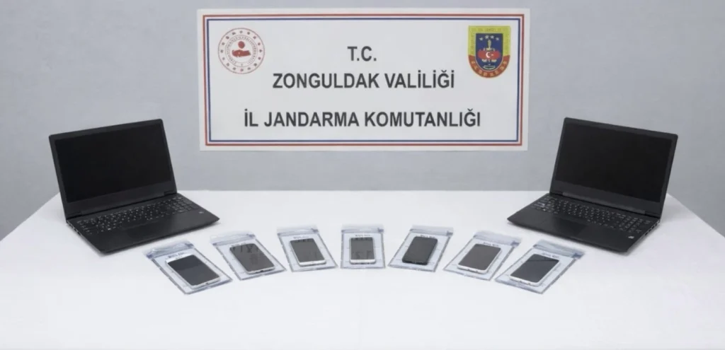 Zonguldak İl Jandarma Komutanlığı'nda sergilenen, internet üzerinden yatırım vaadiyle dolandırıcılık suçunda kullanılan laptoplar ve delil torbalarındaki cep telefonları.