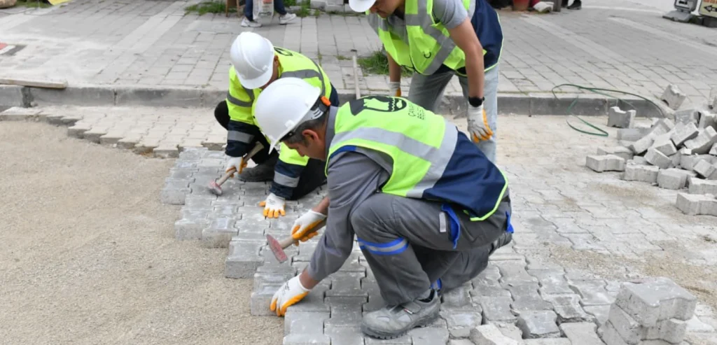 Çanakkale İnönü Caddesi'nde üstyapı yenileme çalışmaları tüm hızıyla devam ediyor. Fen İşleri Müdürlüğü ekipleri kilit parke taşı ve zemin iyileştirme yapıyor.