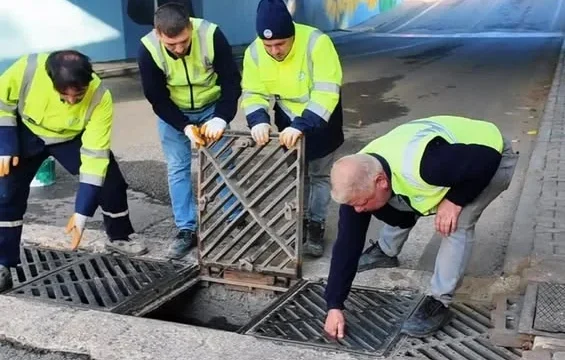 Belediye ekipleri yağmur suyu mazgal temizliği yaparken